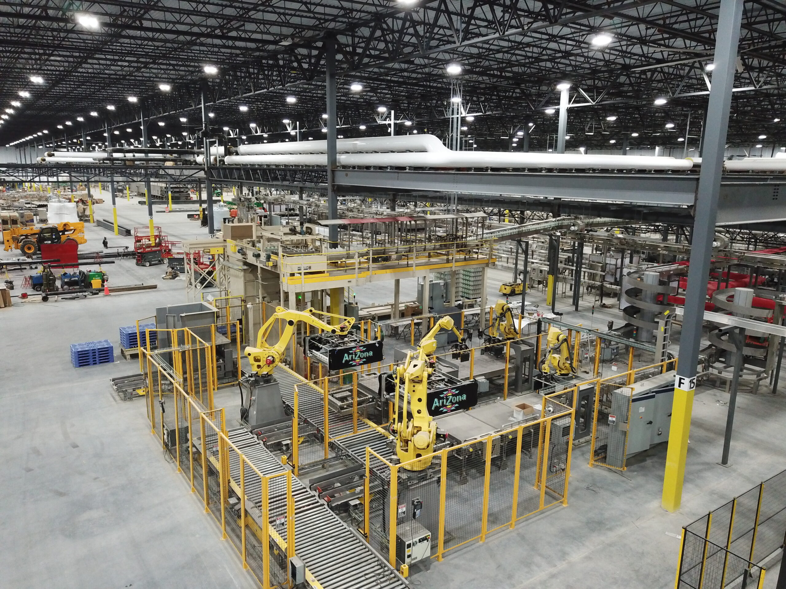 Robotic palletizing cells and conveyor lines inside a large beverage production facility